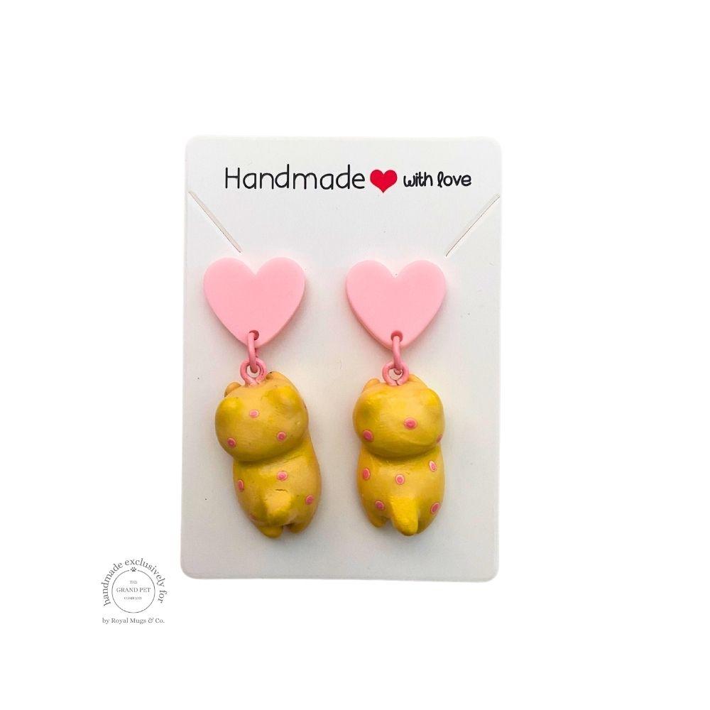 A pair of yellow polka polymer clay earrings in the shape of cats with pink hearts, displayed on a white backing card with 'handmade with love' text.