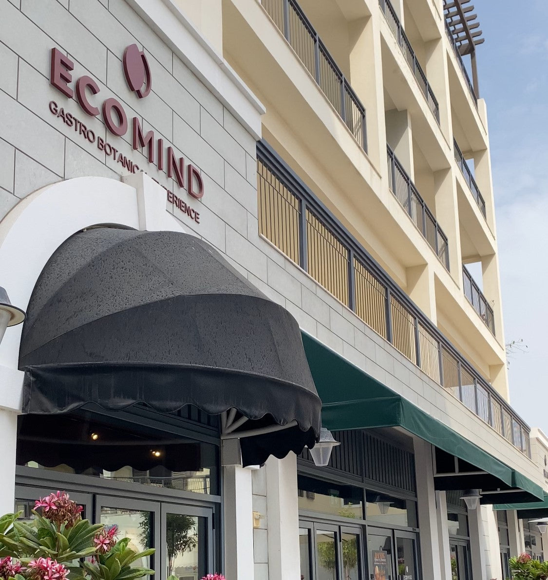 Exterior of Eco Mind Gastro Botanical Café at Port de La Mer Dubai – entrance with black awning and signage; partner of The Grand Pet Company