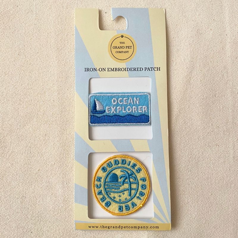 Two beach theme iron-on felt embroidered patches in packaging with 'Ocean Explorer' and 'Beach Buddies Forever' designs.