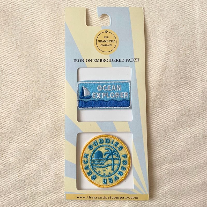Two beach theme iron-on felt embroidered patches in packaging with 'Ocean Explorer' and 'Beach Buddies Forever' designs.