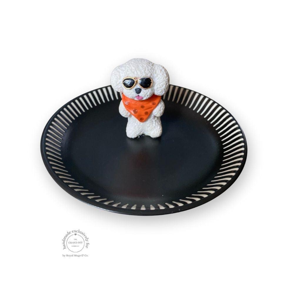 A handmade polymer clay character on a matching ceramic dish.