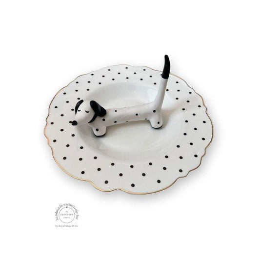 A handmade polymer clay character on a matching ceramic dish.