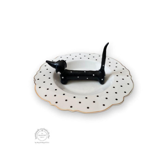 A handmade polymer clay character on a matching ceramic dish.