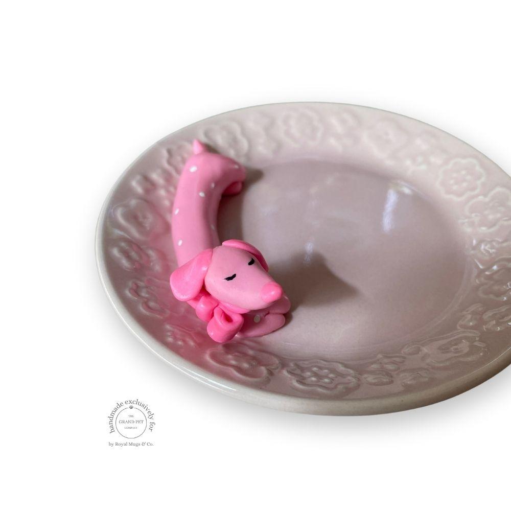 A handmade polymer clay character on a matching ceramic dish.