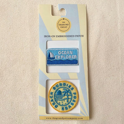 Two beach theme iron-on felt embroidered patches in packaging with 'Ocean Explorer' and 'Beach Buddies Forever' designs.