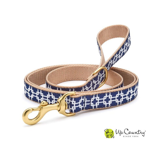 A 5-foot long dog leash with a navy and white gridlock pattern in blue and brown, featuring a solid brass D-ring near the handle.